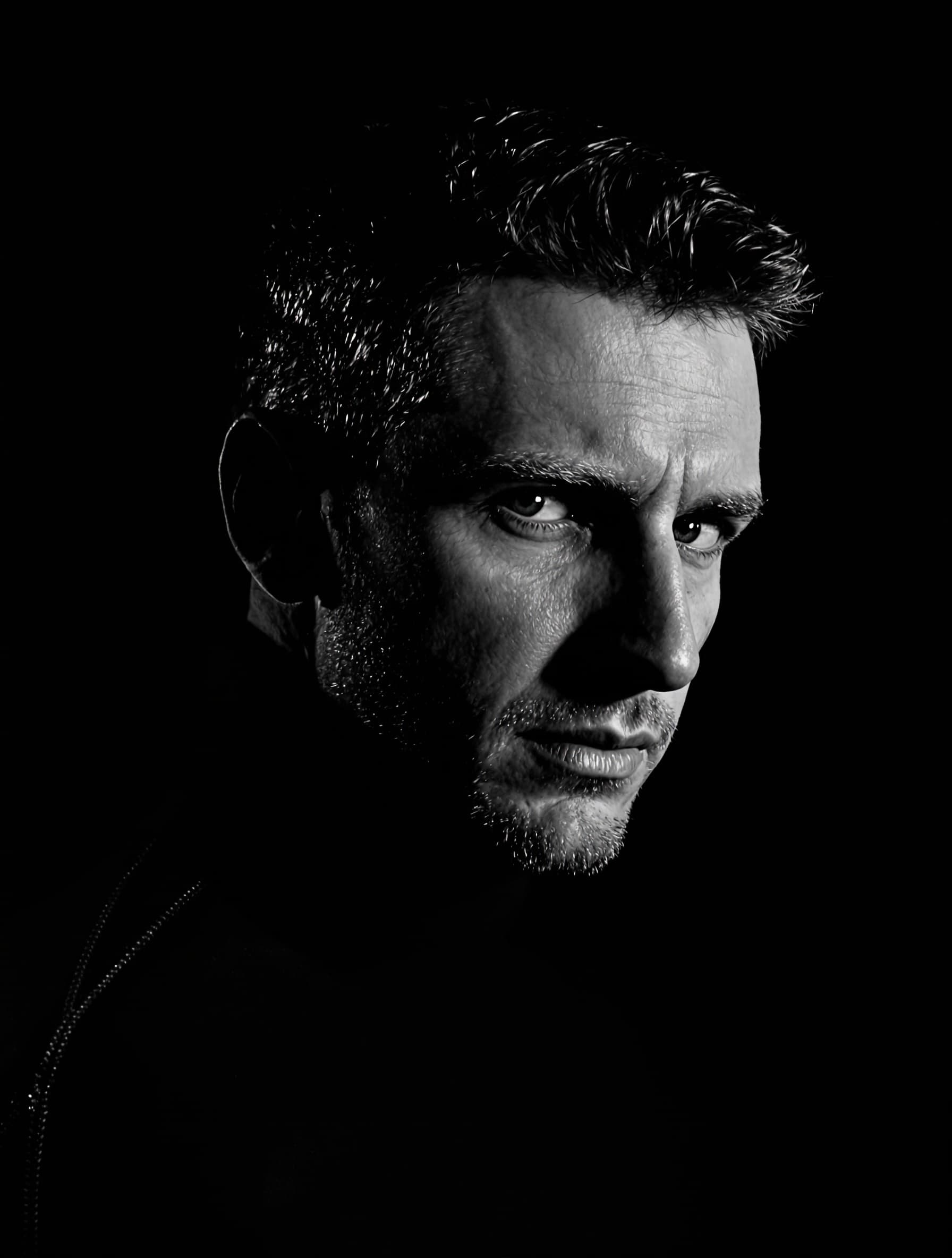 Dramatyczny czarno-biały portret studyjny mężczyzny w golfie — styl Studio B&W
